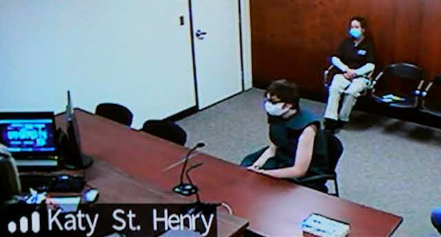 Ethan Crumbley sits on a chair in a courtroom.