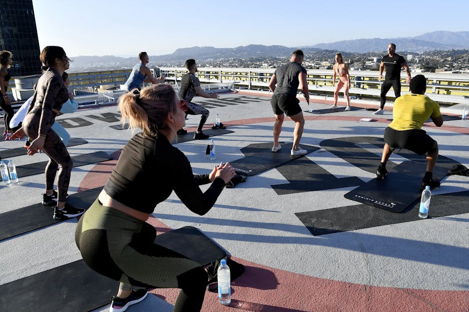 Des sportifs en plein exercice sur le toit d'un immeuble à Los Angeles, 2021