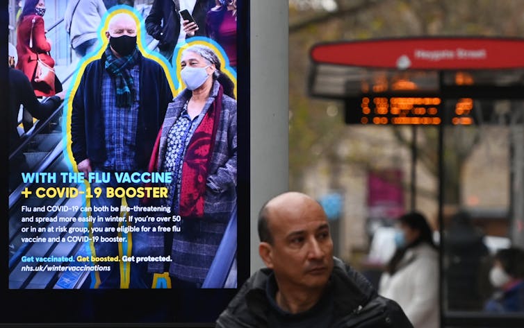 A pedestrian walks past an advertisement