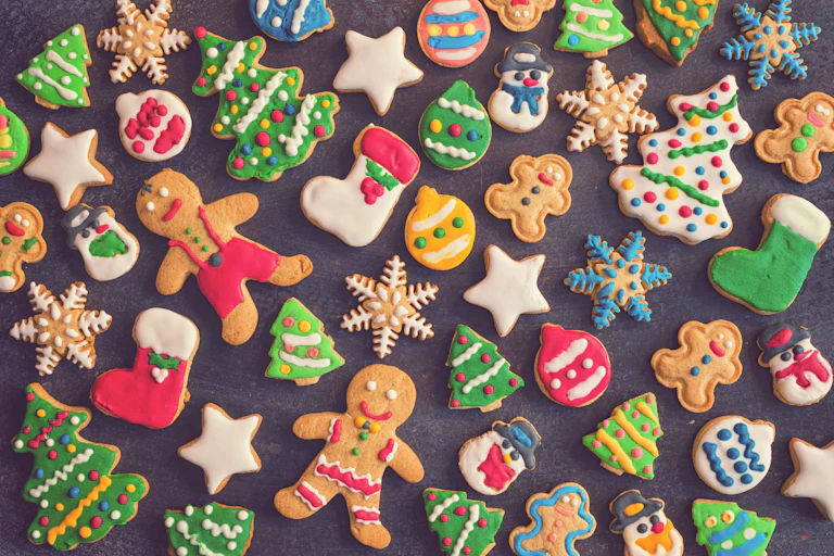 Christmas-themed gingerbread cookies spread out on a grey backdrop.