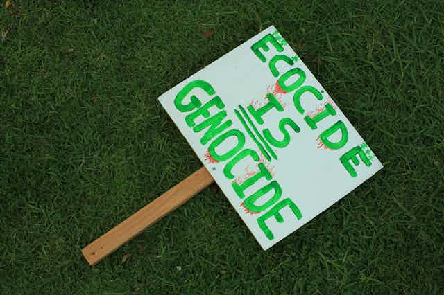 A sign reading 'Ecocide is genocide'
