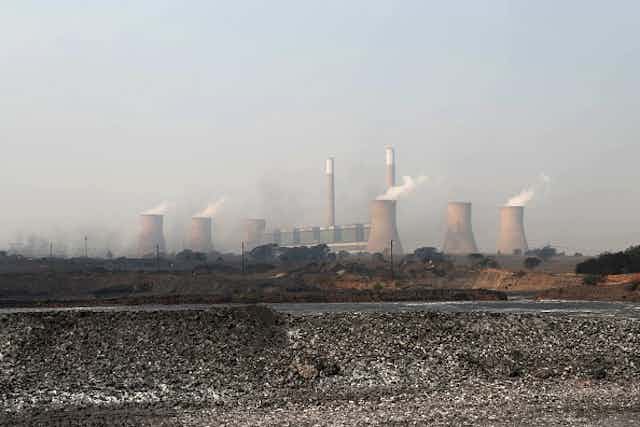 Power plants with smoke in the background.