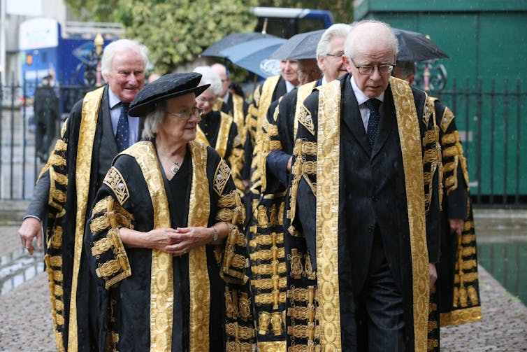 The UK's Supreme Court judges walking into their place of work in full robes.
