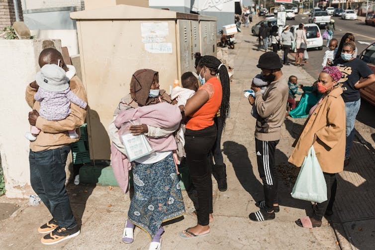 People queue for basic food and baby items at a distribution organised by Muslims for Humanity in Durban