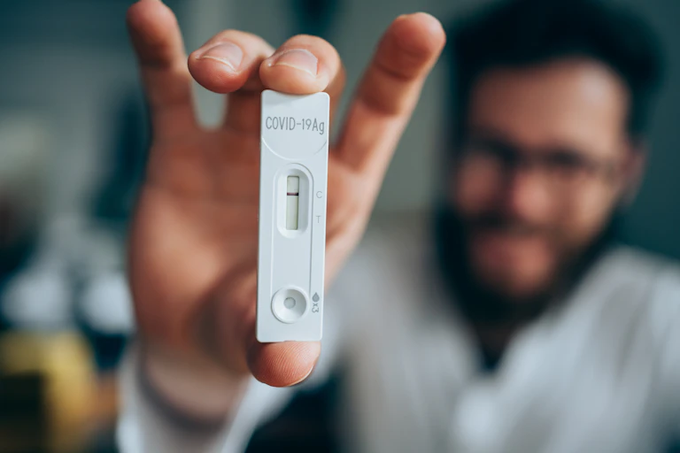 Young man showing his negative Coronavirus/Covid-19 rapid test. Focus is on the test.