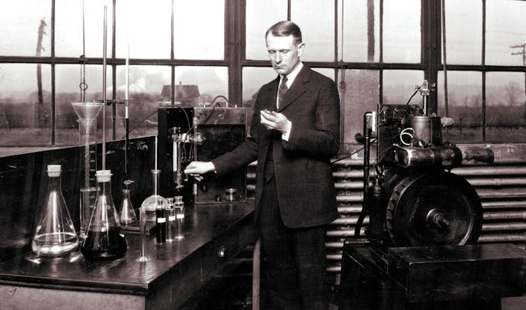 A black and white photo of a man in an old laboratory.