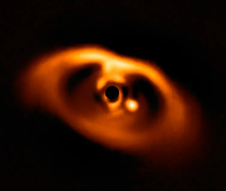 Un pianeta che si sta formando intorno alla stella PDS 70. Un coronografo blocca l'intensa luce della stella per rivelare il pianeta, a destra del centro. Immagine dello strumento SPHERE dal Very Large Telescope dell'European Southern Observatory . ESO / A.Muller et al. , CC BY
