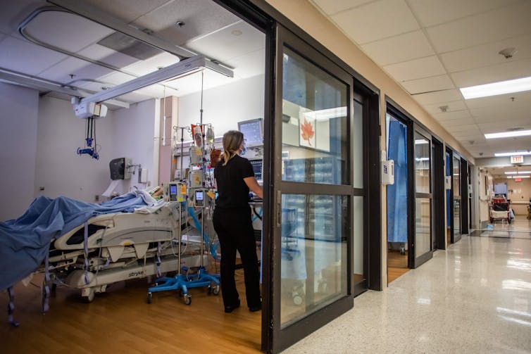 nurse attends a COVID-19 patient on a hospital ward