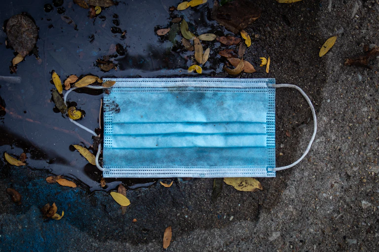 A surgical mask in a puddle.