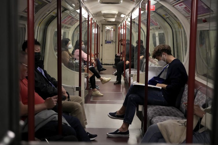 Masked Londoners travel on the tube in winter.
