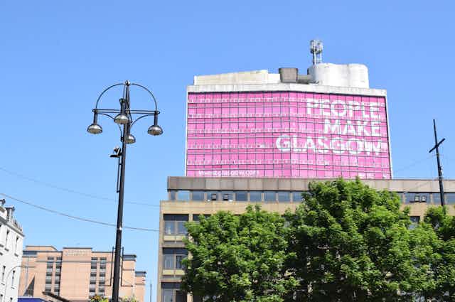 George Square in Glasgow with the big pink building in the background that says 'People Make Glasgow'.