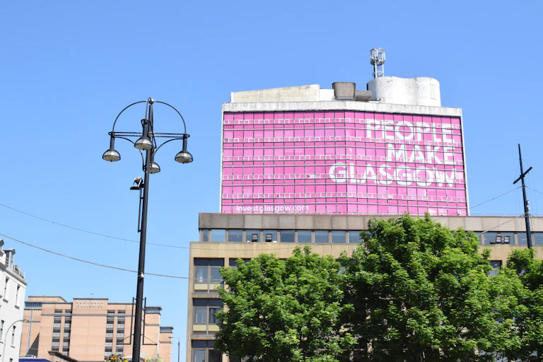 George Square in Glasgow with the big pink building in the background that says 'People Make Glasgow'.