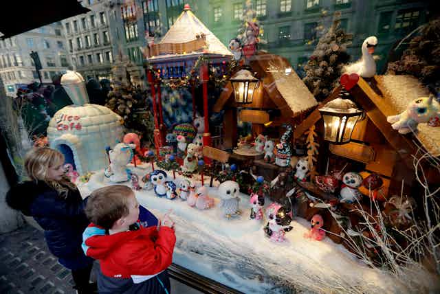 Children look at a toys in a Christmas window display