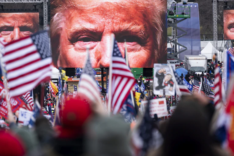 An image of President Donald Trump appears on video screens before his speech to supporters.