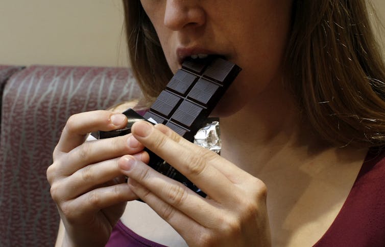 woman eats chocolate bar