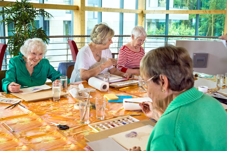 older women painting at table