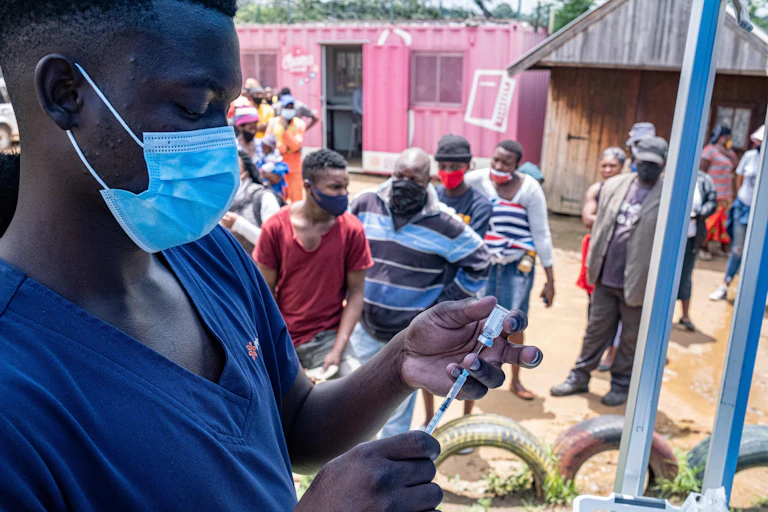 A health worker fills up a syringe with a vaccines dose
