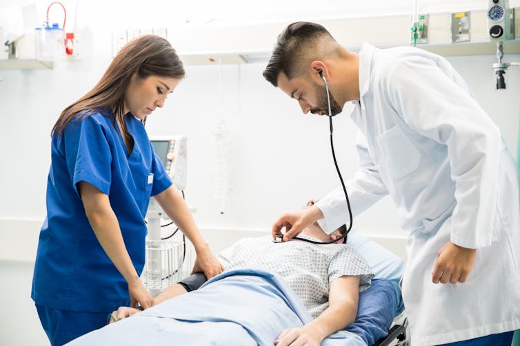 A doctor and nurse are tending to a patient.