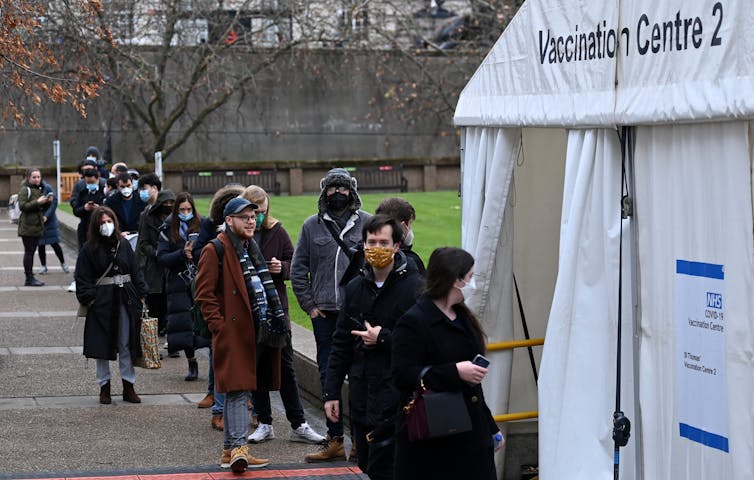 Personas haciendo cola para recibir dosis de refuerzo de la vacuna contra el COVID en el Reino Unido