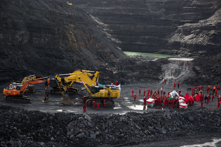 People and a digger in a coal mine