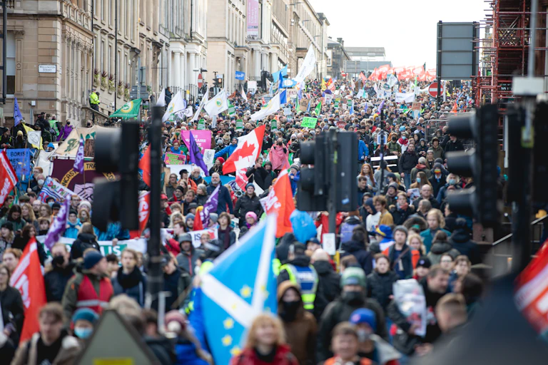 People carrying flags march down a street