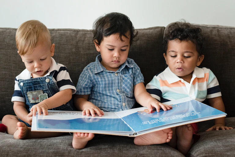 Three kids reading picture book.