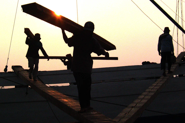 Loggers carrying planks
