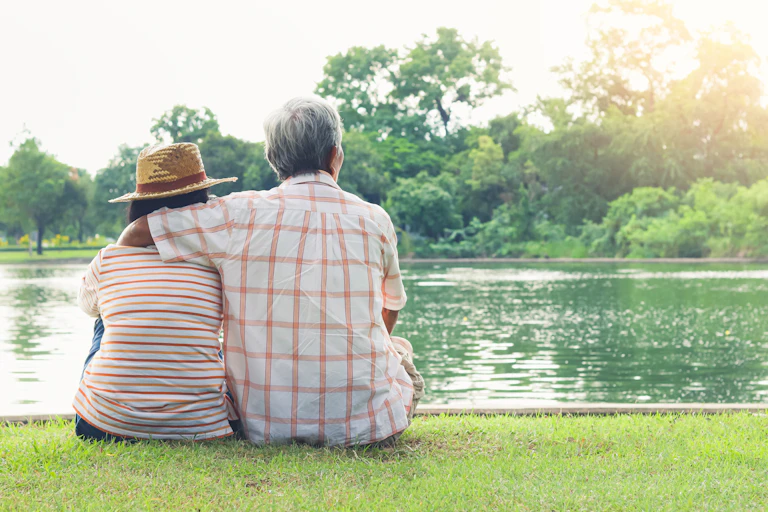 Elderly couple looking at a lake.