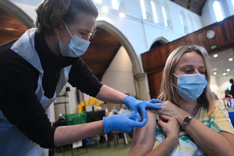 A woman being vaccinated for COVID