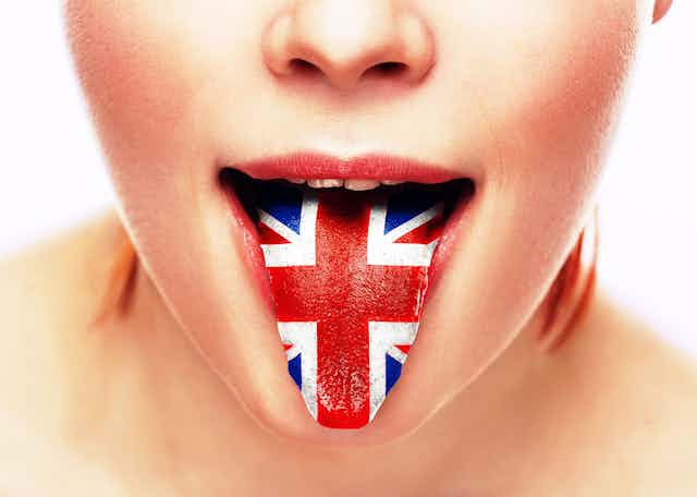 Close-up of a person sticking their tongue out which is painted with the UK flag union jack