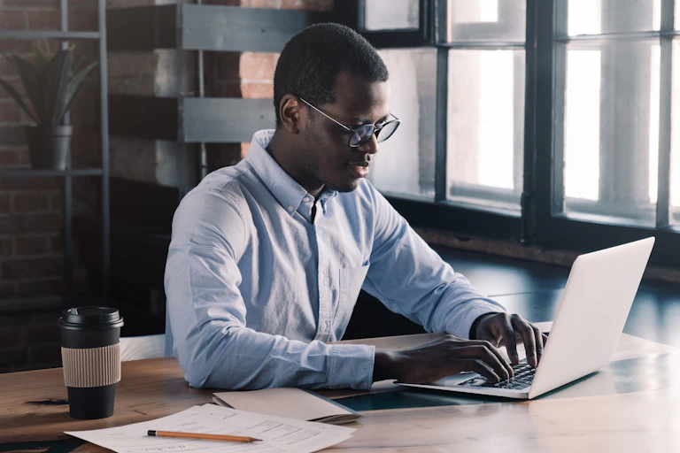 A young man typing on a laptop.