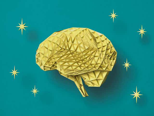 Illustration of brain made of folded yellow paper on a teal background, surrounded by eight-pointed stars.