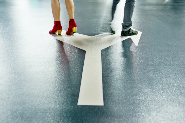 A man and a woman, visible from the knees down, walk in opposite directions.