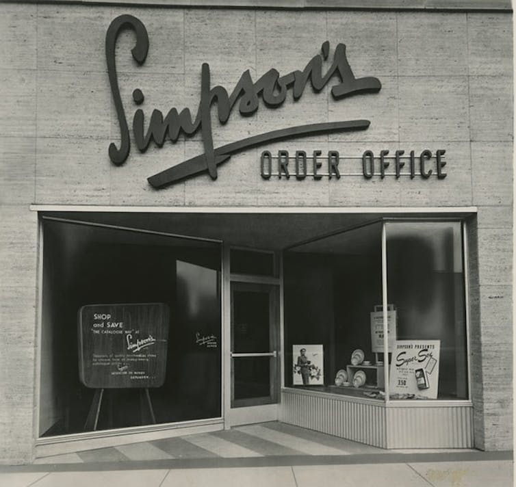 The front window of store on a street says 'Simpson's.'