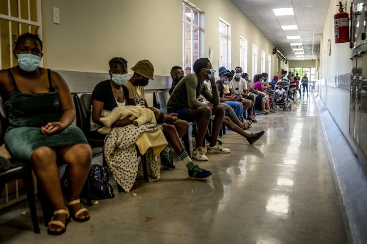 Des gens attendent, assis, leur tour d’être vaccinés