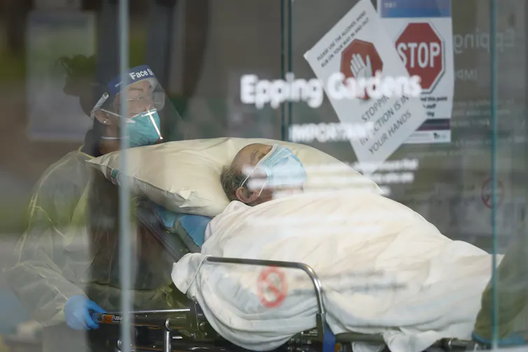 Health worker taking an aged-care resident to an ambulance