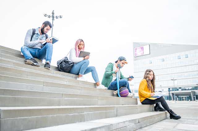 University students sitting outside on steps