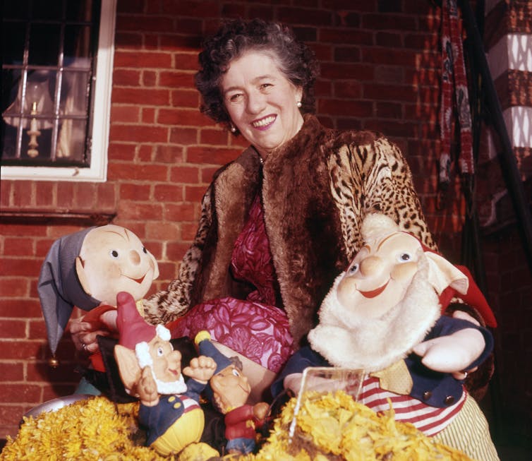 Enid Blyton with toys of characters from Noddy.