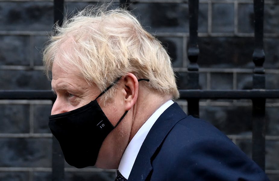 Close up profile shot of Boris Johnson wearing a Number 10 face mask
