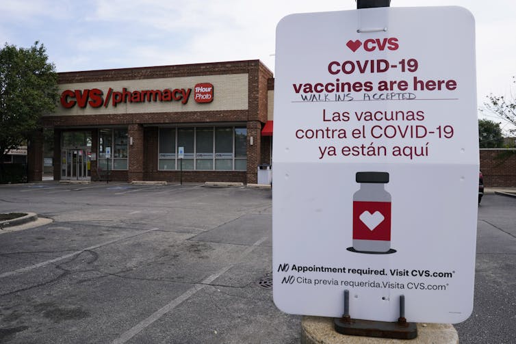 A sign outside a pharmacy stating that vaccines are available for walk-in appointments.