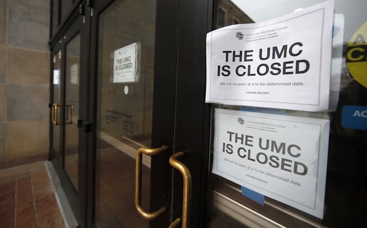 A sign in a door saying that a university building is closed indefinitely.