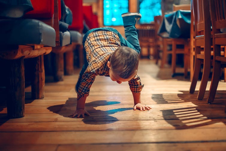Child breakdancing in restaurant.