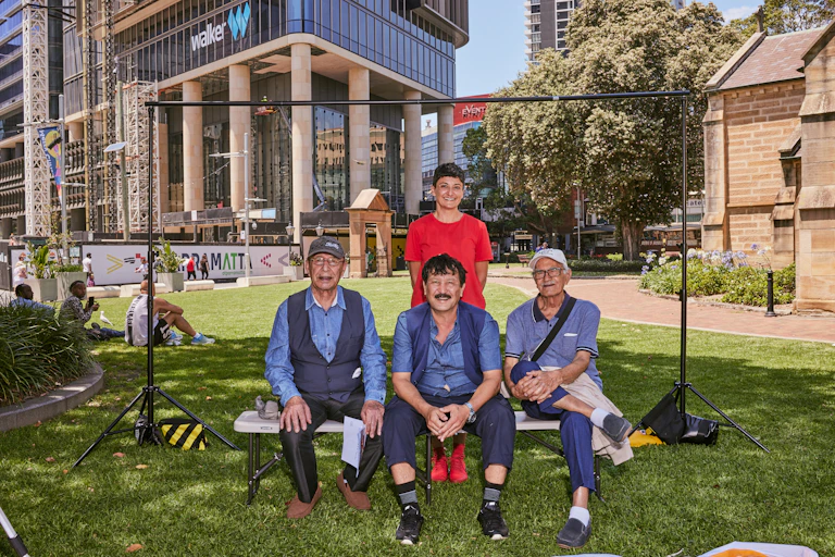 Artist Cherine Fahd stands in a photoshoot with three men in Parramatta City, western Sydney.