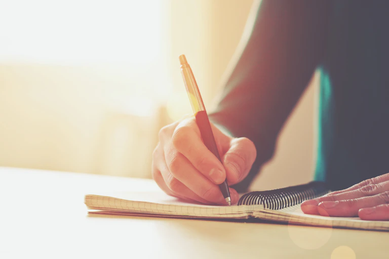 person writing in a notebook.