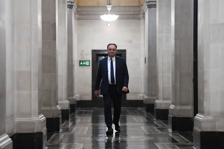Andrew Bailey walking down a corridor