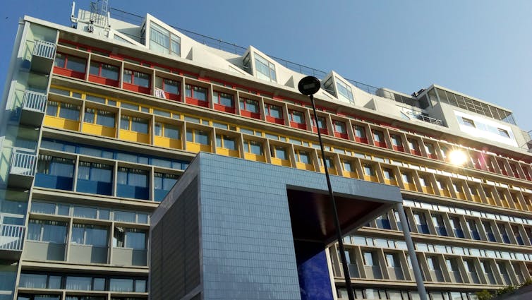An apartment building with red, yellow and blue external features