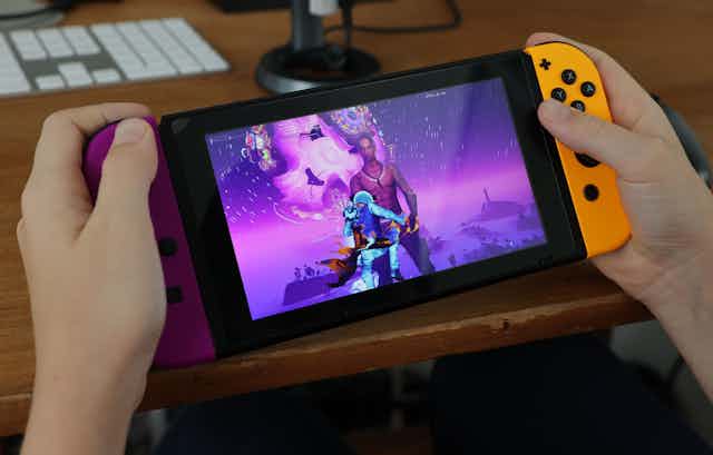 A pair of hands holding a handheld videogame