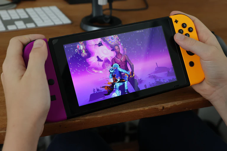 A pair of hands holding a handheld videogame