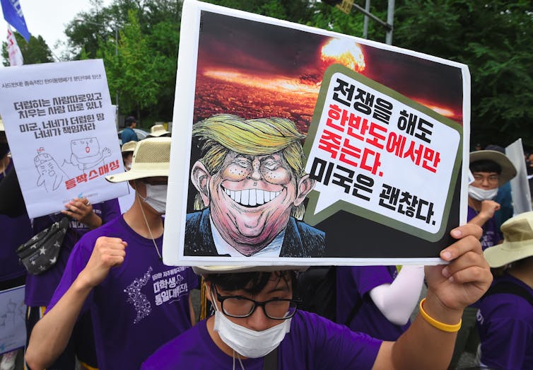 Protesters hold placards.