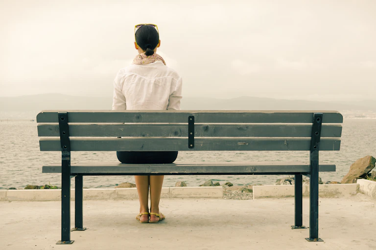 A woman sitting by herself on a bench.